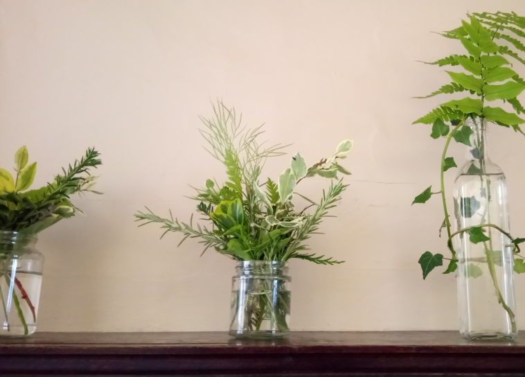 Resourceful wedding foliage - image of mixed foliage in jars and bottles